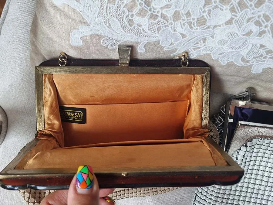 Open vintage Glomesh bag with a gold-tone frame, orange satin lining and a Glomesh Australia label