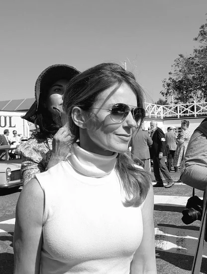 Geri Horner in aviator sunglasses and a white sleeveless polo-neck top at Goodwood Revival, in black and white