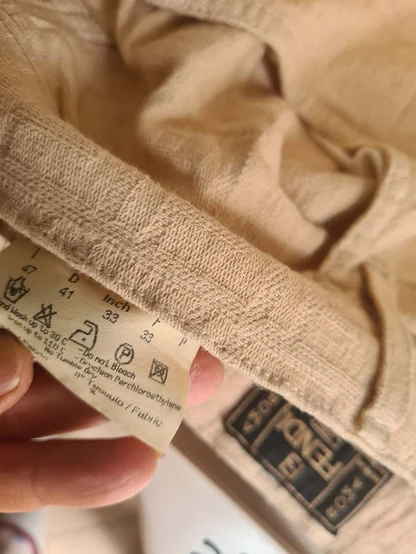 Care label and Fendi Jeans label inside the waistband of beige stretch denim
