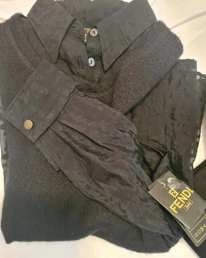 Black wool jumper layered under a sheer black blouse, with a Fendi Jeans tag still attached