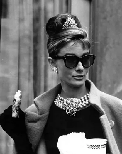 Audrey Hepburn in a Breakfast at Tiffany's look: black sunglasses, jewelled hair ornament, pearl choker and long glove