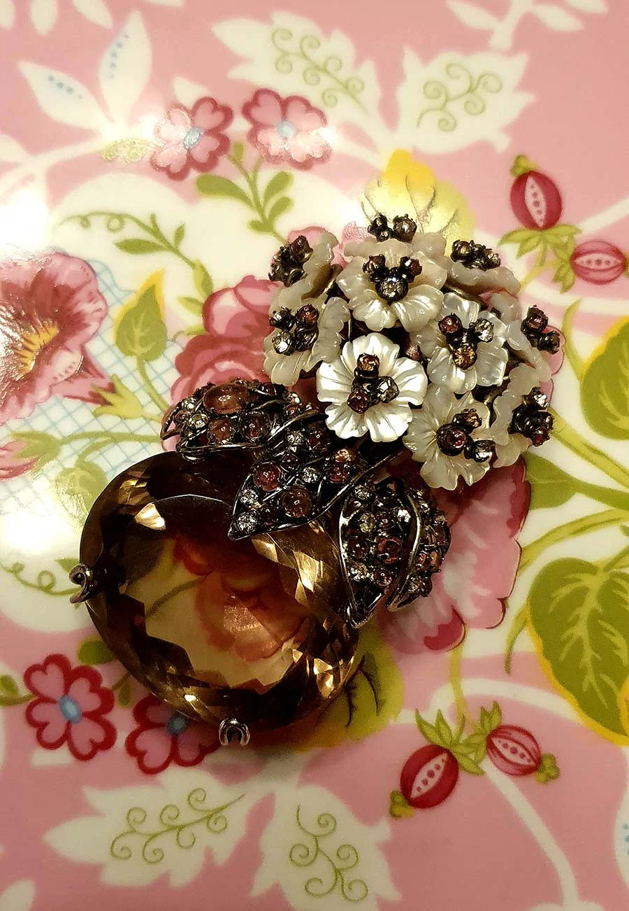 Iradj Moini vintage brooch: mother-of-pearl flowers and rhinestone leaves above a large lemon quartz, on a floral plate