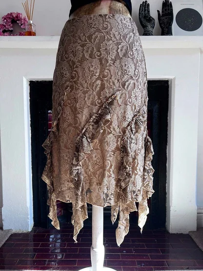 Tan lace skirt with a ruffled, uneven hem on a mannequin in front of a fireplace