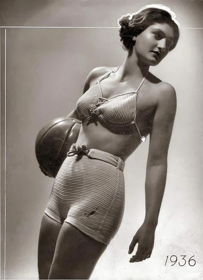 1936 photograph of a woman in a crocheted two-piece swimsuit with a ball tucked under her arm