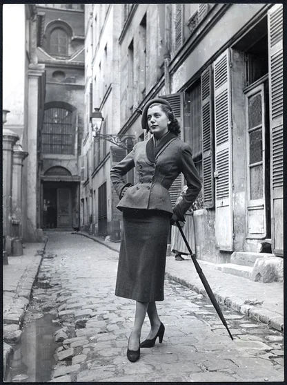 Black-and-white photograph of a Dior Milieu du Siècle suit from Autumn-Winter 1949, with a peplum jacket and narrow skirt