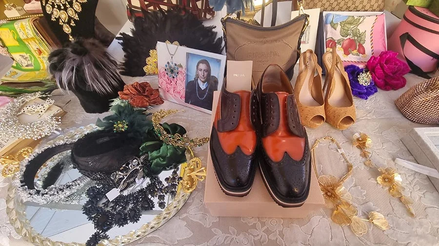 Vintage Prada two-tone black and orange brogues on a stall table among hair accessories and gold-tone jewellery