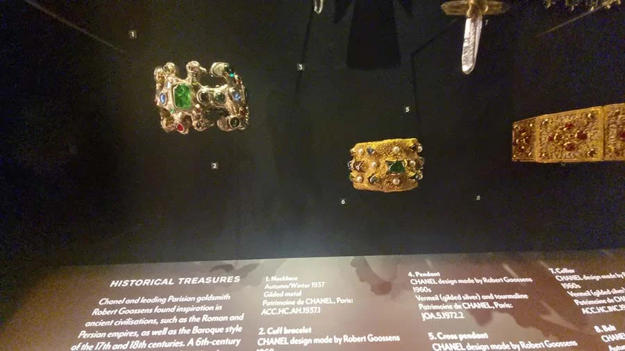 Gilded cuff and bracelet set with green, red and blue stones, under the label 'Historical Treasures'