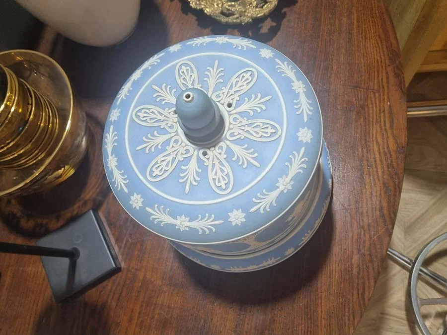 The cheese keeper's lid seen from above, with white leaf and star relief around a small blue knob