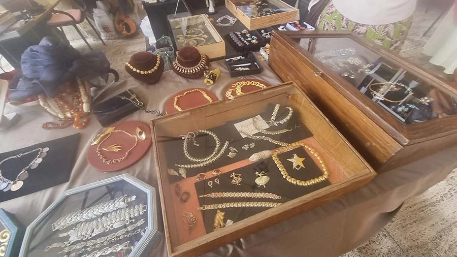 Glass-topped cases of gold-tone vintage necklaces, chains and bracelets on a market stall