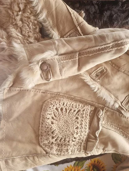 Cream suede-style shearling jacket with a crochet square pocket and fleece trim at the cuff