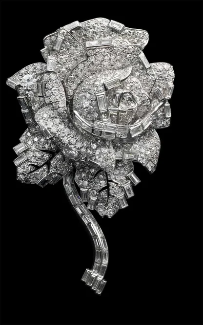 Cartier diamond rose brooch with a baguette-cut stem and petals and leaves set with diamonds, on black