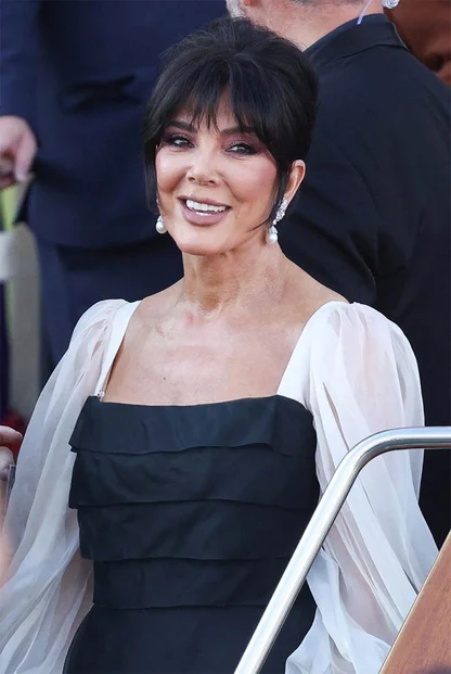 Close portrait of Kris Jenner with dark fringe and pearl earrings, in vintage Valentino in Venice