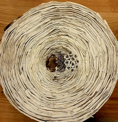 The Iradj Moini brooch set at the centre of a round artwork of coiled paper